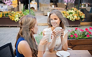 Happy young women drinking coffee at outdoor cafe