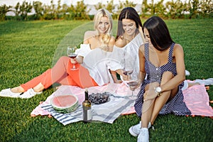 Happy young women friends having a picnic in the country.