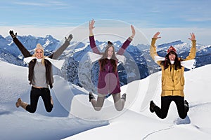 Happy young women jumping in winter in the mountains