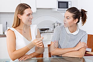 Happy young women looking betrothal ring and chatting together