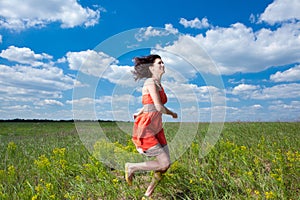 Happy young women running on summer field