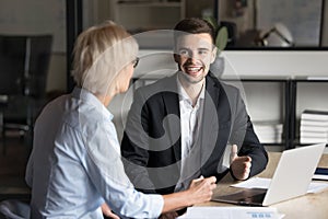 Happy younger business expert man talking to senior customer