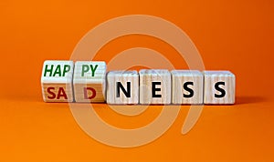 Happyness or sadness symbol. Turned cubes and changed the word `sadness` to `happyness`. Beautiful orange background. Business