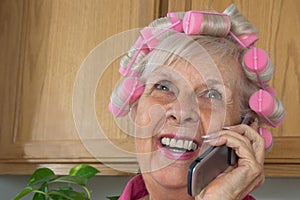 HappySenior Woman in Pink Curlers on Her Cell Phon