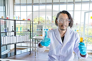 Hapyy success scientist doctor showing thumbs up and holding test tube. Scientist doctor is smilling in complete research and new