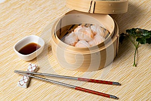 HAR GOW in bamboo steamer with sauces and chopsticks. Chinese Traditional cuisine concept. Dumplings Dim Sum in bamboo steamer