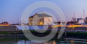 The harbor of blankenberge lighted at night, white building and houses, popular city architeture photo