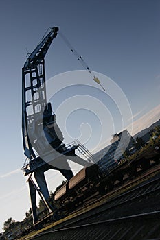 Harbor crane over boxcars in blue sky