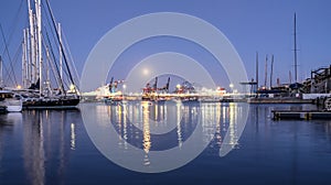 harbor docked sailboats cargo port cranes full Moon sky and water reflection horizon night lighting