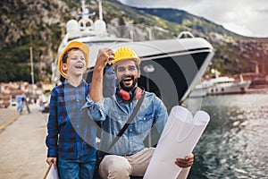 Harbor engineer with his son holding the paper, construction work