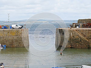 Harbor entrance and pier in the harbor of Mousehole in Cornwall England photo