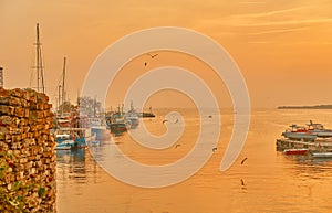Harbor with moored boats in the old town of Nessebar. Beautiful landscape in the golden setting sun.