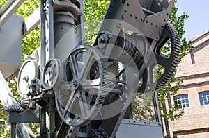 Harbor old crane hoist gearing metal in gray.