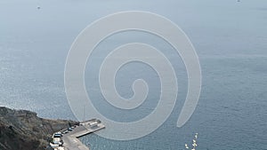 Harbor Ormos Athinios at Santorini Isle Greece. Aerial view over the Calders with its volcano isle Nea Kameni