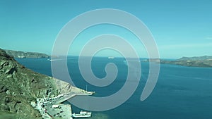 Harbor Ormos Athinios at Santorini Isle Greece. Aerial view over the Calders with its volcano isle Nea Kameni