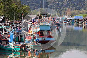 Harbor on a river with colorful wooden boats and ships.