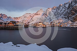 Harbor, rorbuer and snowy mountains at sunrise in Ãâ¦, Lofoten, N