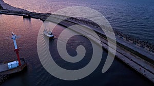 Harbor with ship sailing to port during sunset