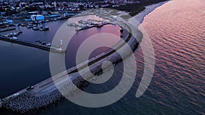 Harbor with ship sailing to port during sunset