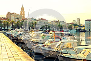 Harbor of Split city at golden hour with lots of boats moored there