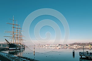 In harbor of TravemÃ¼nde lies the old sailing ship Passat in winter and the sky is cloudless and blue