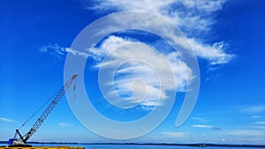 harbor and yellow cranes on blue sky