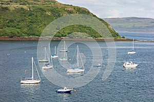 The harbour in Portree, Isle of Skye, Scotland at early sunset with a lot of ships