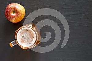 Hard Apple Cider Ale in a Glass Jar Mug on a black surface, top view. Flat lay, overhead, from above. Space for text