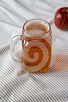 Hard Apple Cider Ale in a Glass Jar Mug on cloth, low angle view