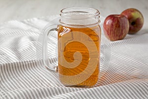 Hard Apple Cider Ale in a Glass Jar Mug on cloth, side view. Close-up