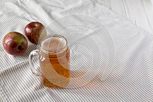 Hard Apple Cider Ale in a Glass Jar Mug on cloth, side view. Copy space