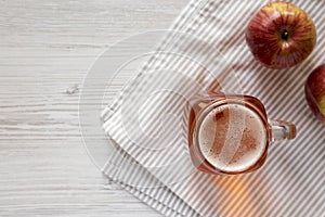 Hard Apple Cider Ale in a Glass Jar Mug on a white wooden background, top view. Flat lay, overhead, from above. Copy space