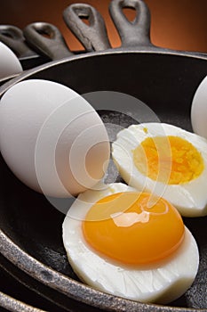Hard boiled egg with fresh yoke in one half, all in cast iron skillets