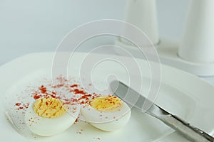 Hard boiled eggs sliced halves in white plate