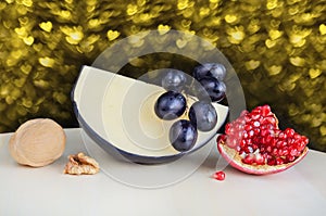 Hard cheese and various fruits on the table. Bokeh in the shape of hearts on the background