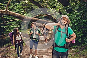 Hard, difficult, tiring and exhausting expedition of four friends in wild forest in trail. Guy is struggling of a neck pain, massa photo