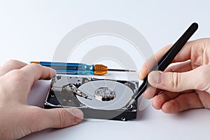 Hard disc drive disassembling close up. Repairman opening hdd for recovery information, service center and electronics repair con