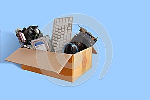 Hard disks and motherboards and old computer hardware accessories, Electronic waste in paper boxes isolated on blue background,