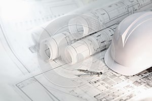 Hard hat and compass on architectural blueprints and construction technology and future industry