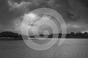 Hard lightning strike with black clouds in cyclone storm