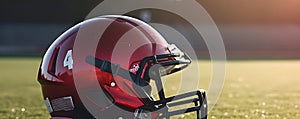 Hard protective red sport helmet of american football player on green grass