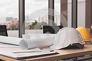 Hard safety helmet hat, construction equipment, blueprint on table in office worker conference site, architect working desk.