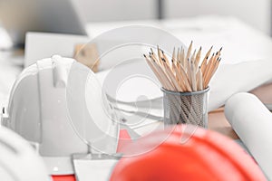 Hard safety helmet hat, construction equipment, blueprint on table in office worker conference site, architect working desk.