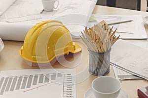 Hard safety helmet hat, construction equipment, blueprint on table in office worker conference site, architect working desk.