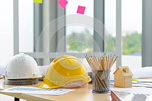 Hard safety helmet hat, construction equipment, blueprint on table in office worker conference site, architect working desk.