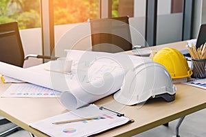 Hard safety helmet hats, construction equipment, blueprint on the table in conference office worker, architect working desk.