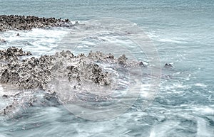 Hard silver colored rocks and blue water