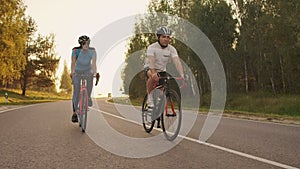 Hard Training.Triathlete two Cyclist Training On Road Bicycle. two Cyclist Riding On Road Bike In City Park And Getting