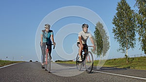 Hard Training.Triathlete two Cyclist Training On Road Bicycle. two Cyclist Riding On Road Bike In City Park And Getting