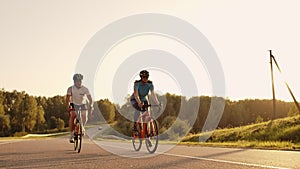 Hard Training.Triathlete two Cyclist Training On Road Bicycle. two Cyclist Riding On Road Bike In City Park And Getting